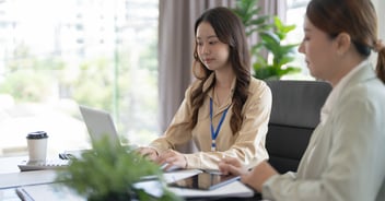 Thai banker reviewing nonperforming loan portfolio using an AI-driven collections platform to prioritize accounts and automate workflows